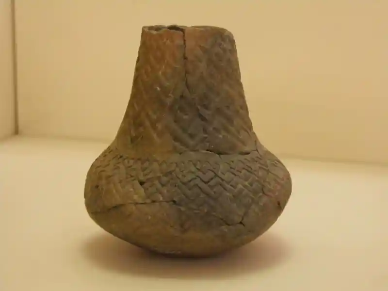 Cross from zigzig pattern and connected diamonds engraved on a clay vase